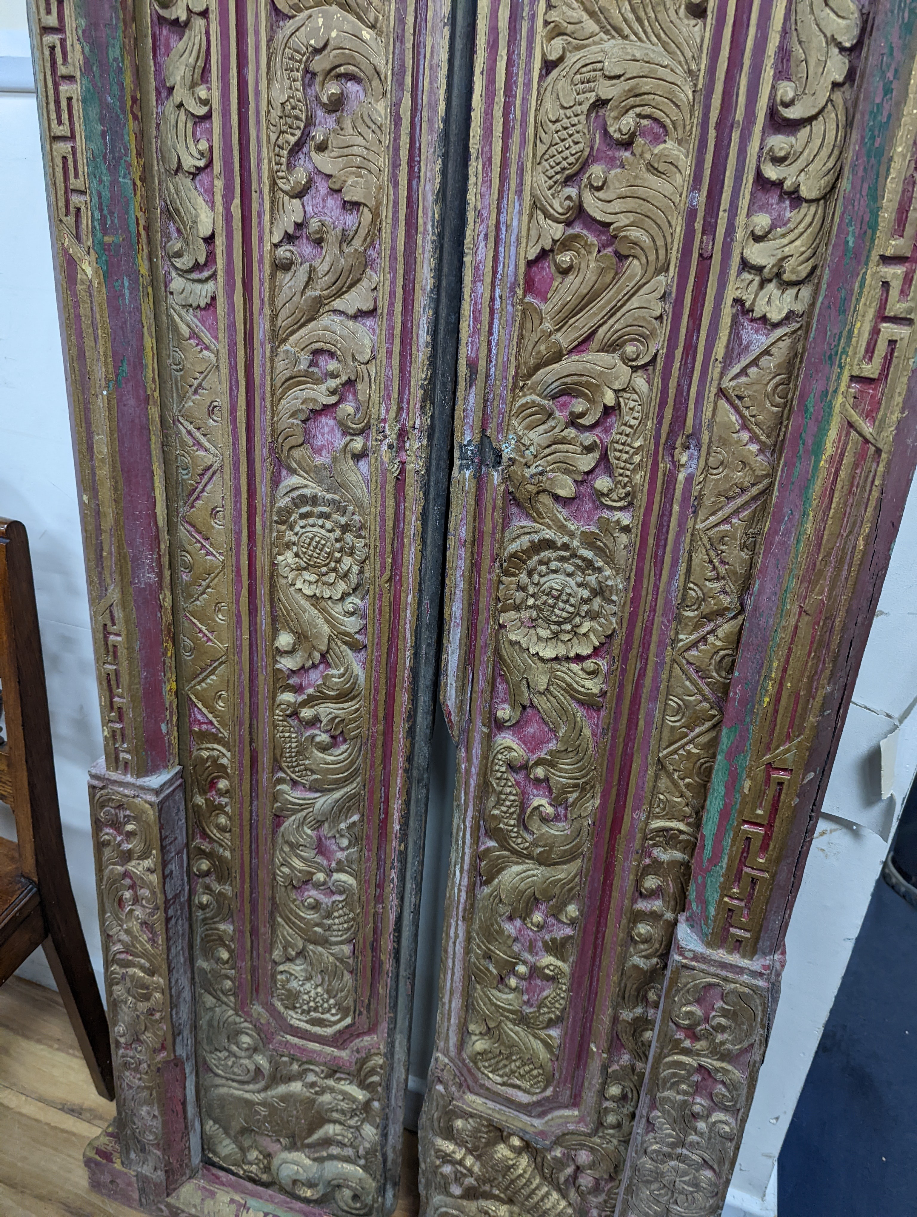 A Balinese carved giltwood door and frame, painted and gilded, width 83cm, height 174cm